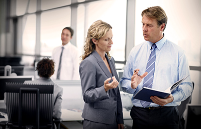 Two Business People Standing Discussing Document