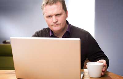 Man at Computer Looking Puzzled