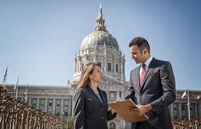 Two-Businesspeople-Standing-in-Front-of-Capitol-Building